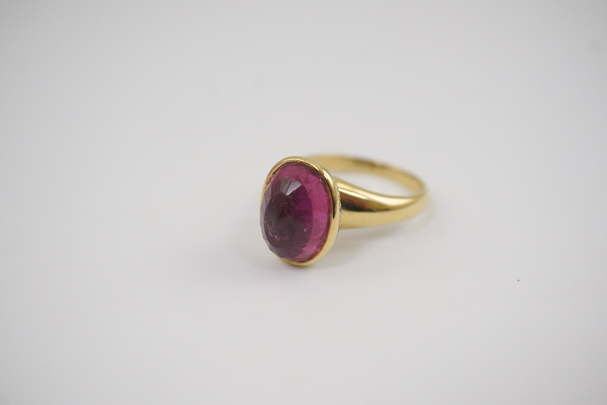 A modern 18k gold and single stone fancy oval cut deep pink tourmaline set dress ring, signed Asprey?